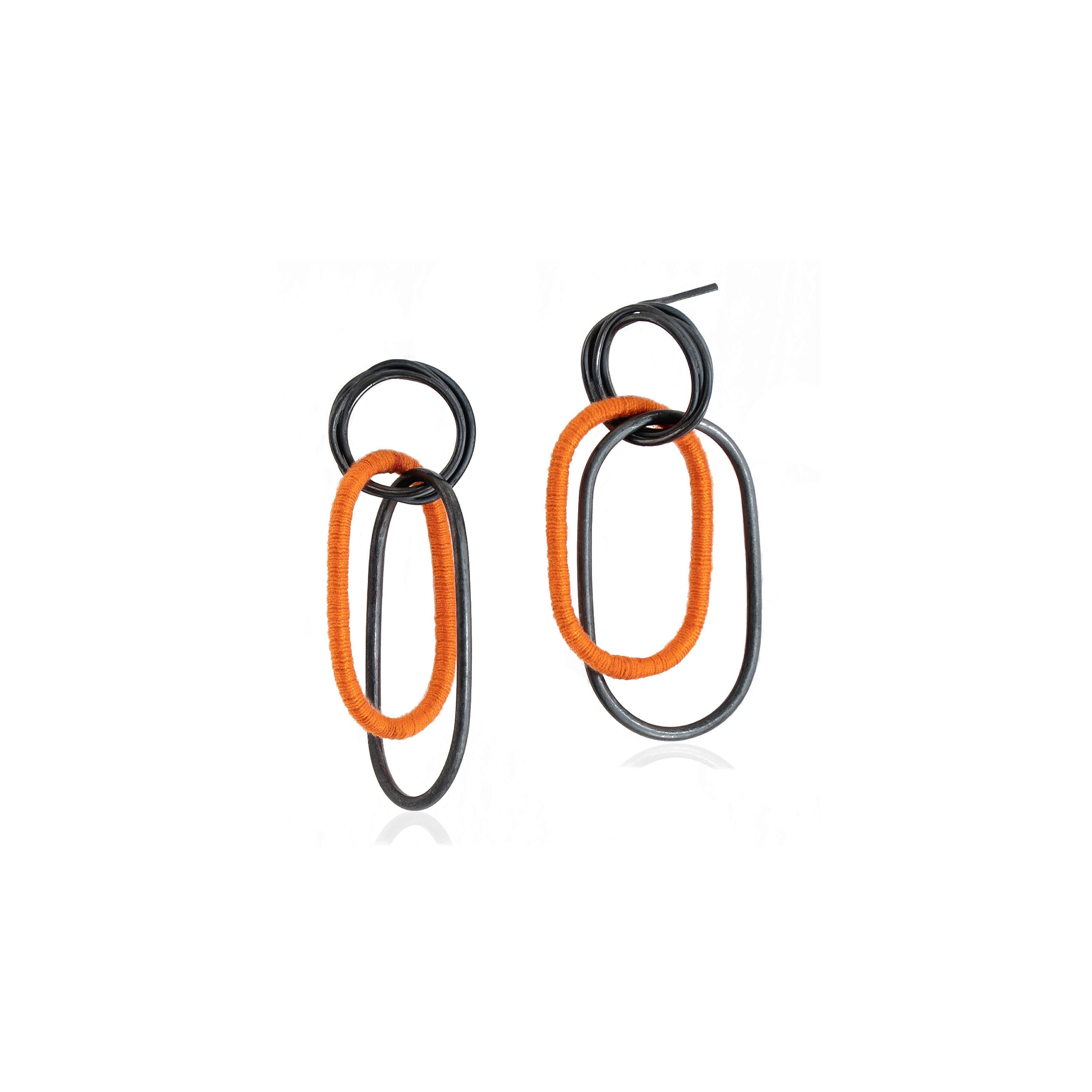 Oxidized Sterling Silver Coiled Stud Earrings with interlocking wire dangles, with one dangle wrapped in orange cotton thread are handmade in Adelaide, South Australia by Melissa Gillespie Jewellery