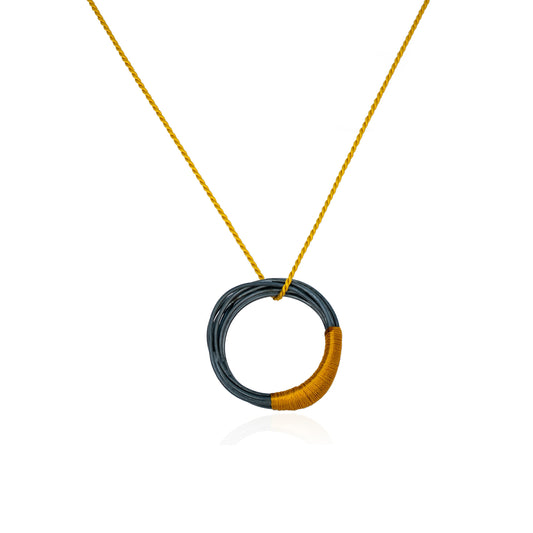 Circular oxidized sterling silver pendant with mustard silk cord, handmade in Adelaide, South Australia by Melissa Gillespie Jewellery