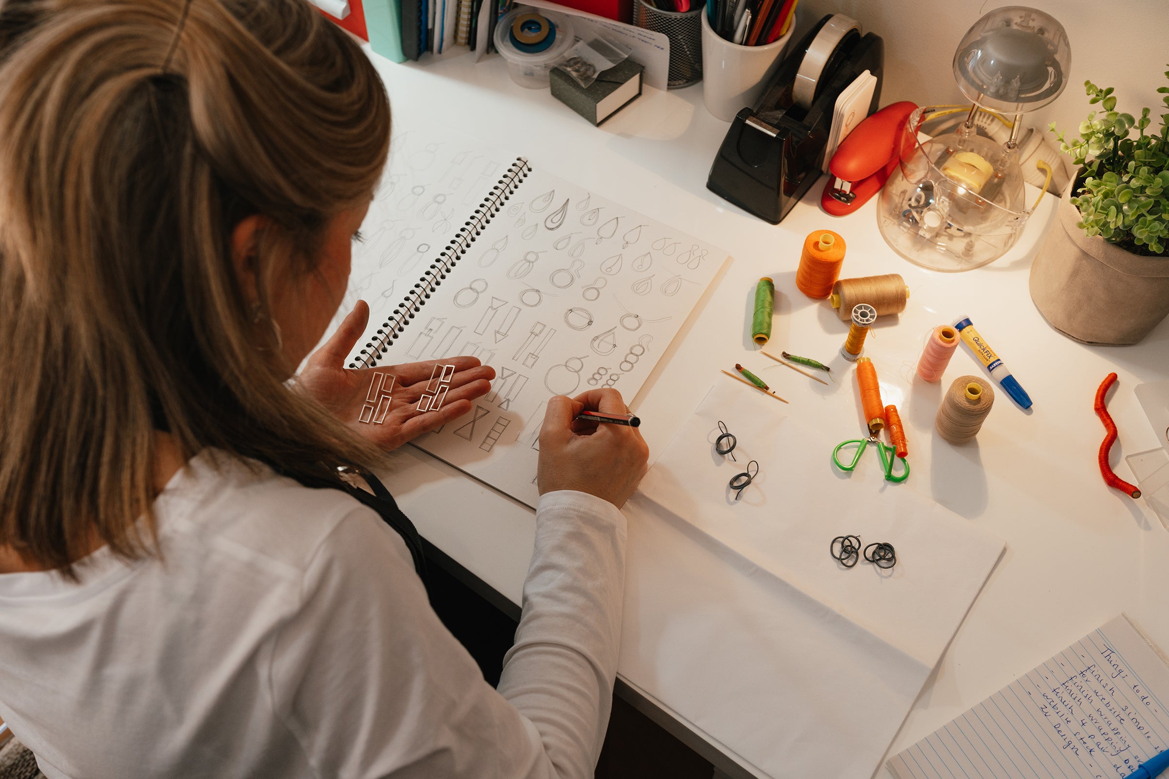 Melissa Gillespie at her jewellery desk sketching designs for earrings in Sterling Silver from her home studio in Adelaide, South Australia.