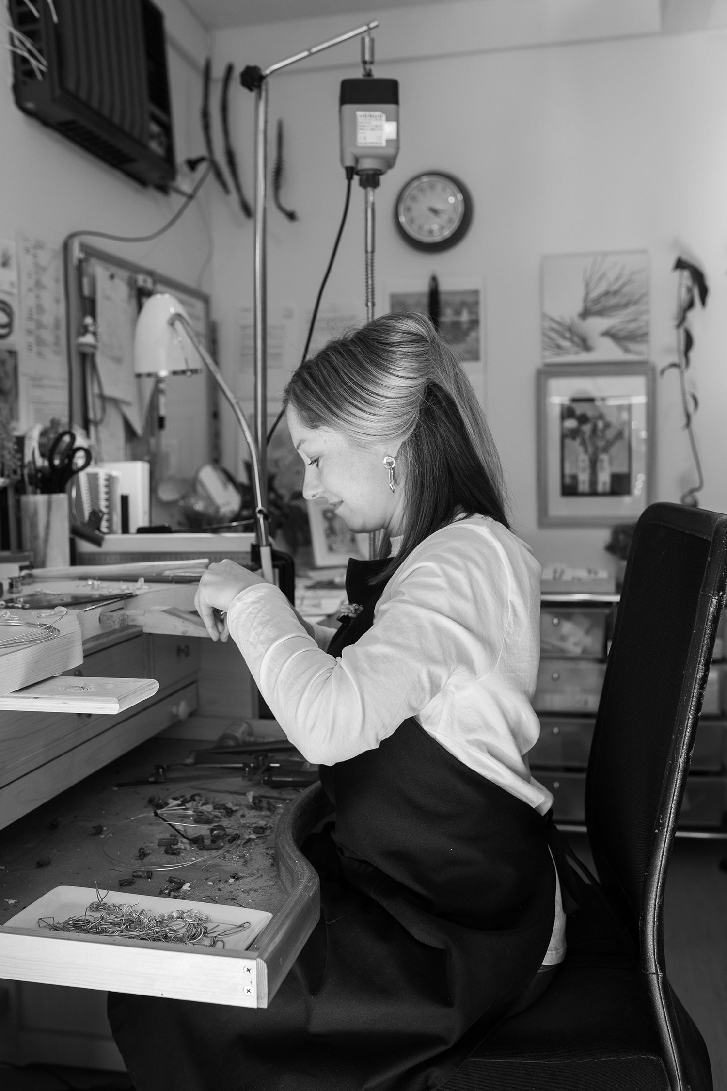 Melissa Gillespie sitting at her jewellery bench inside her home studio in Adelaide, South Australia creating unique Contemporary Jewellery from Sterling Silver wire, such as Earrings, Neckpieces and Bangles.