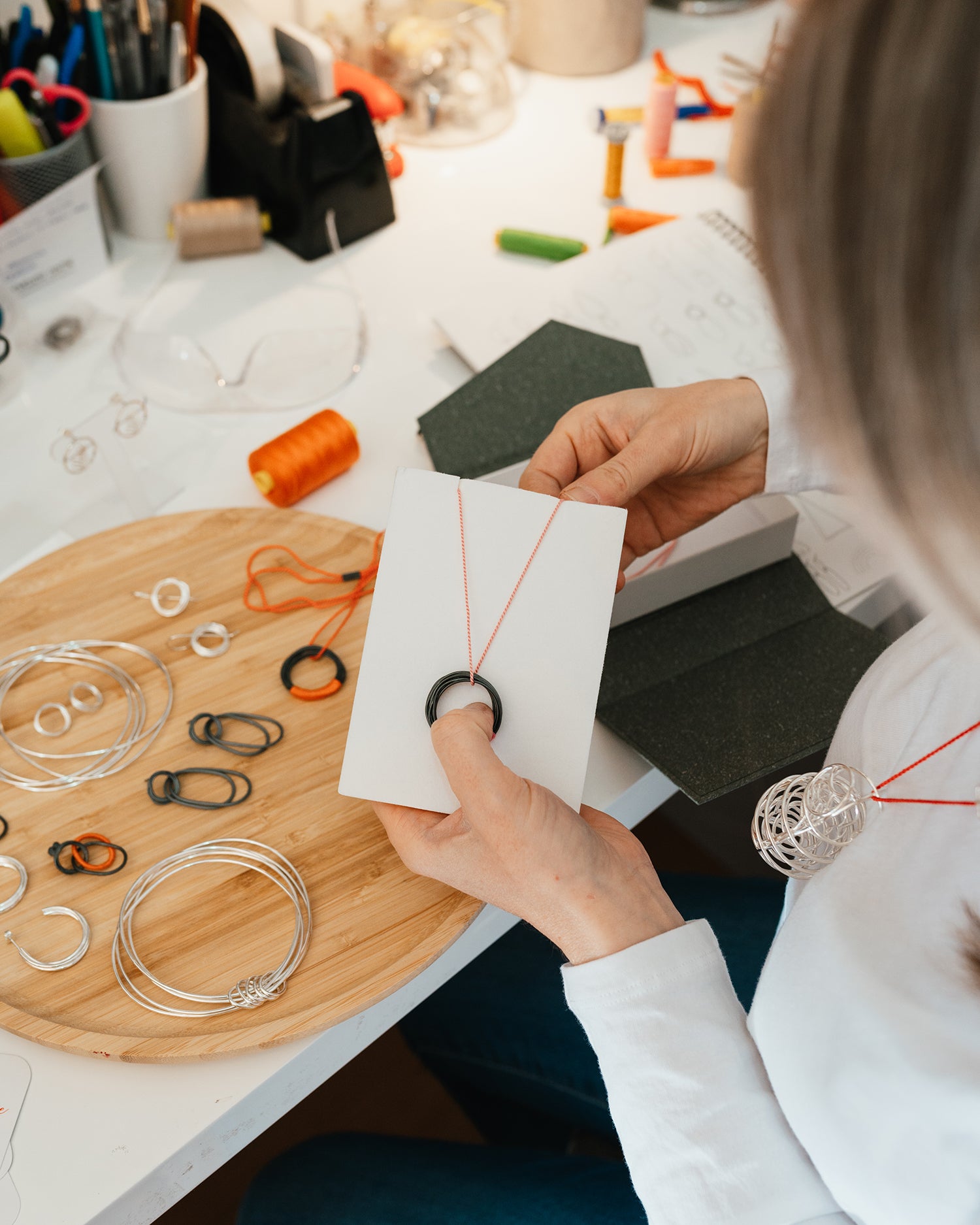 Melissa Gillespie at her jewellery desk inside her home studio placing a new sterling silver and wrapped pendant onto a foam piece to place inside a personalized gift box. Melissa Gillespie's jewellery is always placed inside it's own gift box for her special customers.